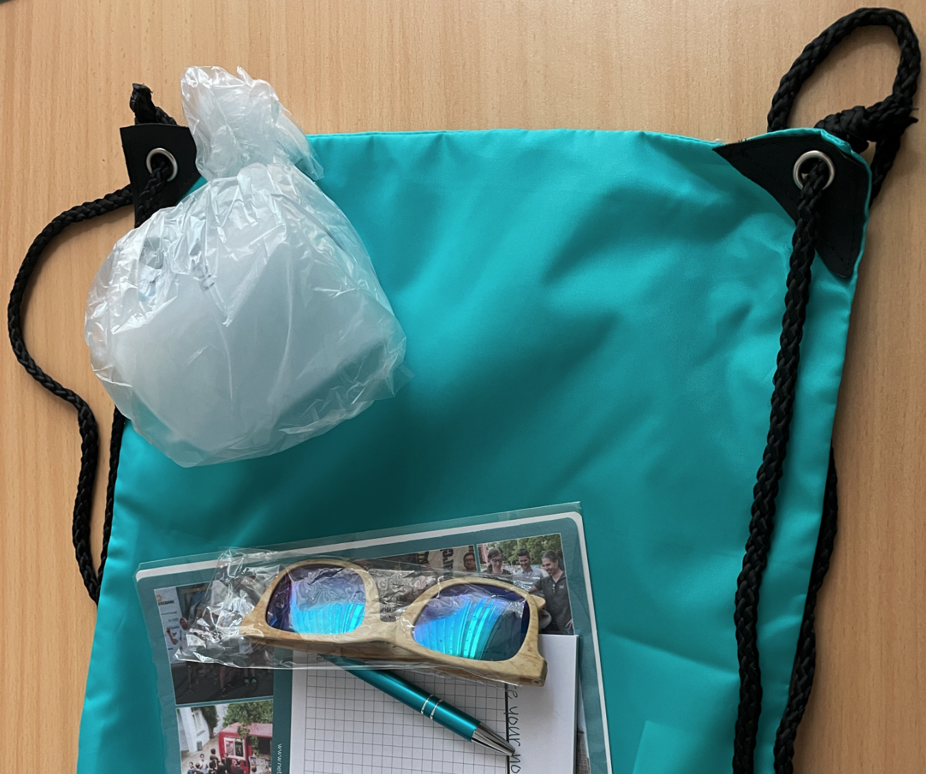 Coding battle prizes including a turquoise drawstring bag, sunglasses and promotional materials